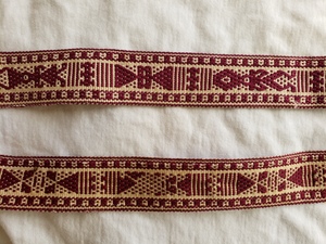 Handwoven maroon and cream cotton ribbon with figural patterns