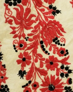 Red and black floral embroidery on cream linen