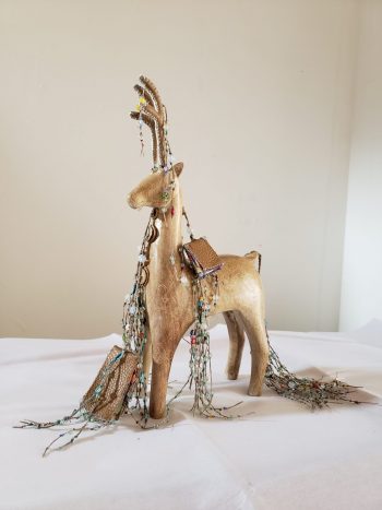 Wooden deer sculpture decorated with green glass bead tassels